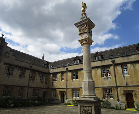 a statue stands tall in the oxford courtyard